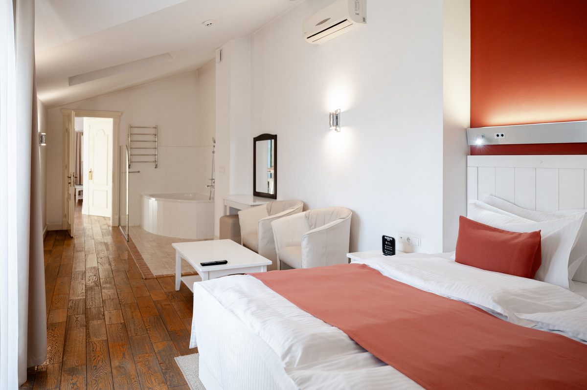 Das Schlafzimmer: das Doppelbett, zwei Sessel und die Badewanne im Raum