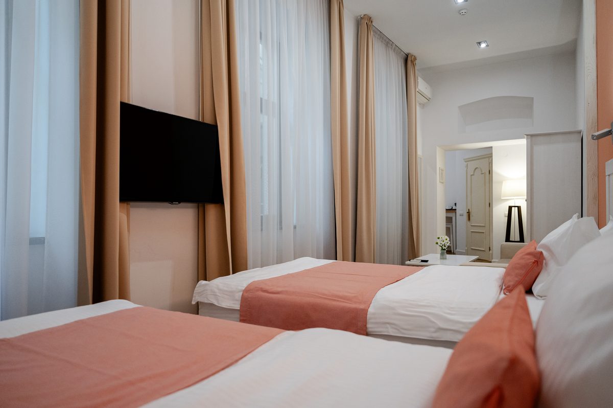 Junior Suite: łóżka, telewizor na ścianie i długie zasłony